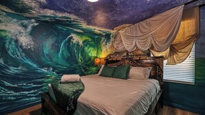 A bedroom with a mural of a wave, a bed with a headboard, and a window with curtains. - Pirate Lux Villa w/ Pool, Spa & Arcades, Near Disney, coffee, waffles bar (Davenport)