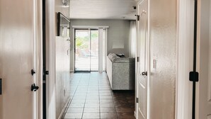 A hallway with a tiled floor, white walls, and a ceiling with a decorative light fixture. - Resort Style Heated Pool close to Entertainment (Phoenix)