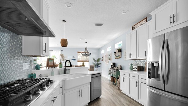 A modern kitchen with white cabinets, stainless steel appliances, and a central island.