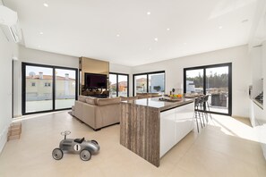 Un apartamento moderno con una isla de cocina, un sofá y un comedor.