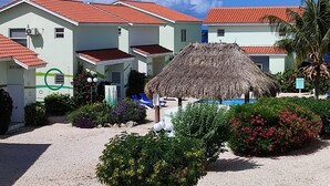 Ein Resort mit mehreren Gebäuden, einem Gebäude mit Strohdach und einem Poolbereich.