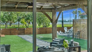 A covered outdoor seating area with a view of a lake and trees. - Historic Waterfront 3/2 With Yard & Soaking Tub (Lake Worth)