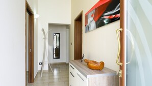 A hallway with wooden doors, a mirror, and a wooden cabinet with a decorative object. - Grandma Cecilia's terrace (Lecce)