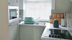 A kitchen with a window, sink, and cabinets. - 1 bedroom accommodation in Pickering (Pickering)