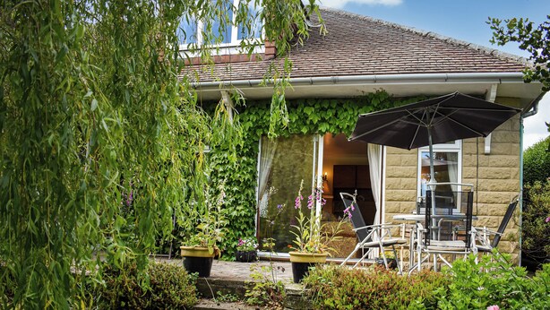 A house with a garden, outdoor furniture, and a large umbrella. - 1 bedroom accommodation in Pickering (Pickering)