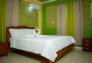 A neatly made bed with a white bedspread and a swan-shaped pillow arrangement. - Incognito Vacation Stay (Kingston)