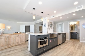 A modern kitchen with a central island, built-in oven, and stainless steel appliances. - Luxury Living from the 9th Floor of Silver Shells (Destin)
