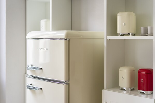 Un refrigerador de estilo vintage con un compartimento congelador, dispensador de hielo incorporado y dispensador de agua.