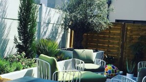A patio with a dining table and chairs, surrounded by greenery and a wooden fence. - Pleasant new house Angers Centre-Madeleine (Angers)