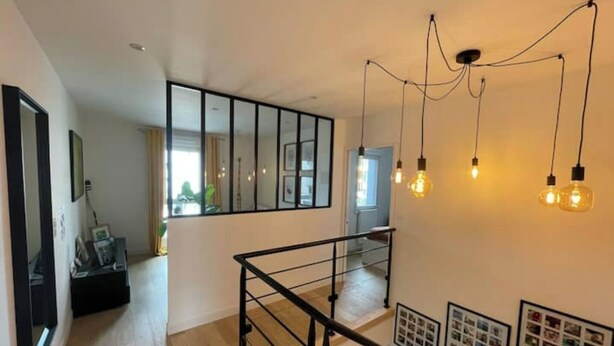 A modern interior with a staircase, a large mirror, and hanging light fixtures. - Pleasant new house Angers Centre-Madeleine (Angers)