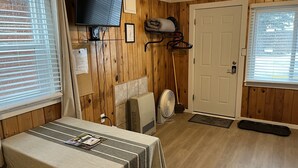 A compact room with a bed, a TV mounted on the wall, a heater, and a door. - Cozy cabin #3 in mountains near Rio Grande River (South Fork)