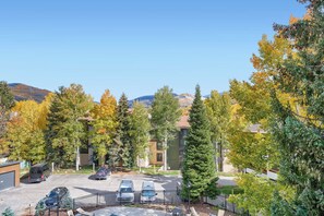 Ein Wohngebiet mit Parkplatz, mehreren Gebäuden und Bäumen im Herbstlaub.
