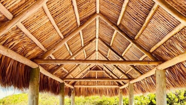 A covered wooden deck with a thatched roof, surrounded by natural scenery. - "Tropical Oasis" by the beach & shops, with pool (Riviera Beach)