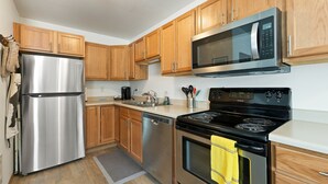 A modern kitchen with stainless steel appliances, wooden cabinets, and a granite countertop. - Modern Downtown Kalispell Getaway — Walk to Coffee, Shops & Breweries (Kalispell)