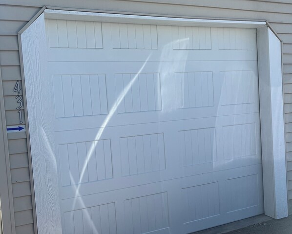 A white garage door with a blue arrow pointing to the left. - Modern Downtown Kalispell Getaway — Walk to Coffee, Shops & Breweries (Kalispell)