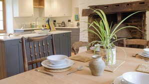Un coin repas avec une table en bois, des chaises et un vase contenant des plantes vertes.