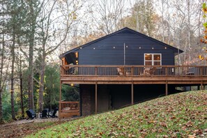 A cabin with a wooden deck and outdoor seating area.