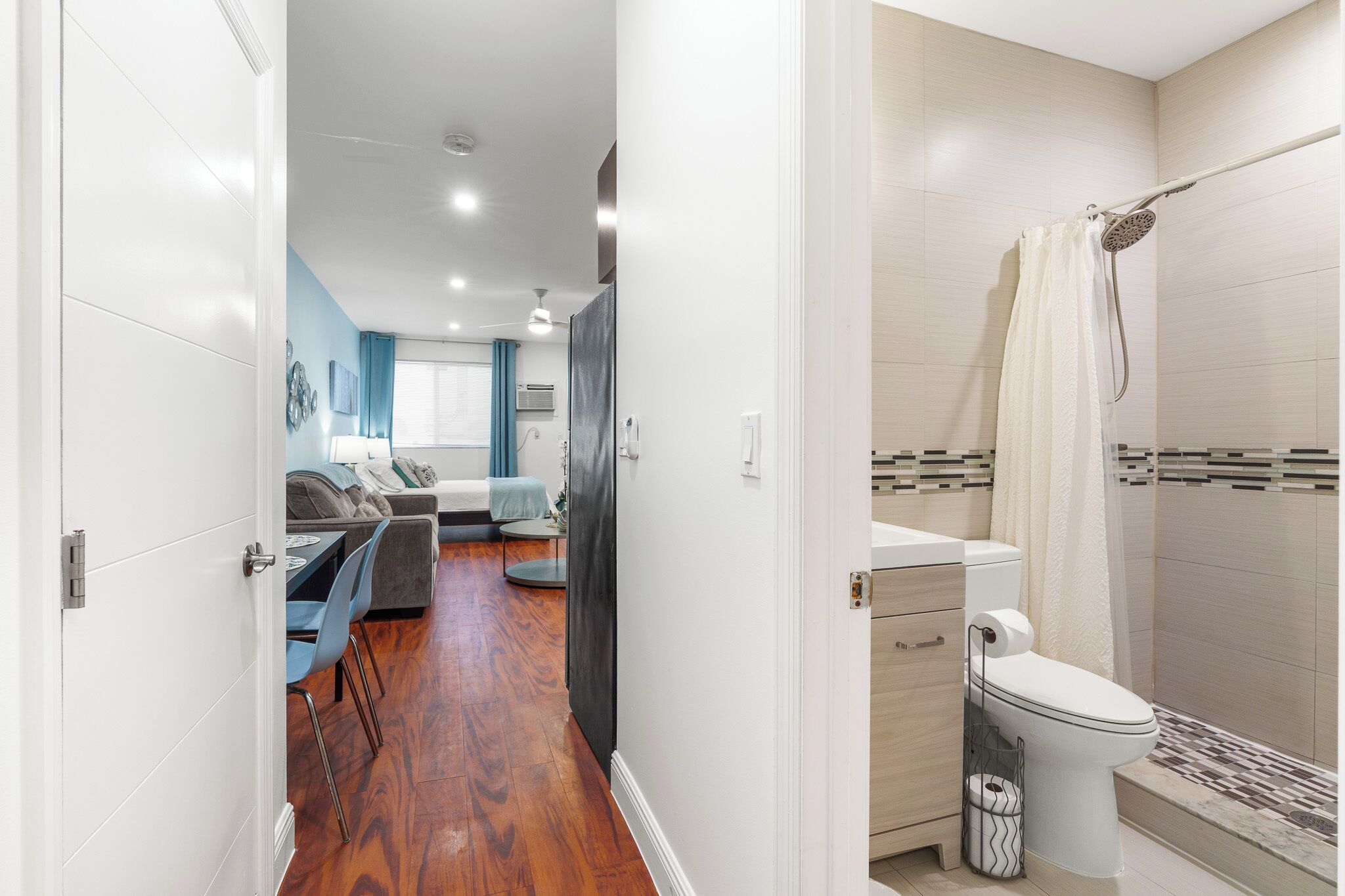 A modern bathroom with a shower, toilet, and sink.