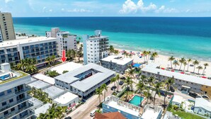A coastal hotel with multiple buildings, a beach, and a pool area.