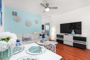 Standaard appartement, 1 kingsize bed, niet-roken (Suite Eight) | Woonruimte | Een 65-inch flatscreentelevisie met satellietzenders en televisie