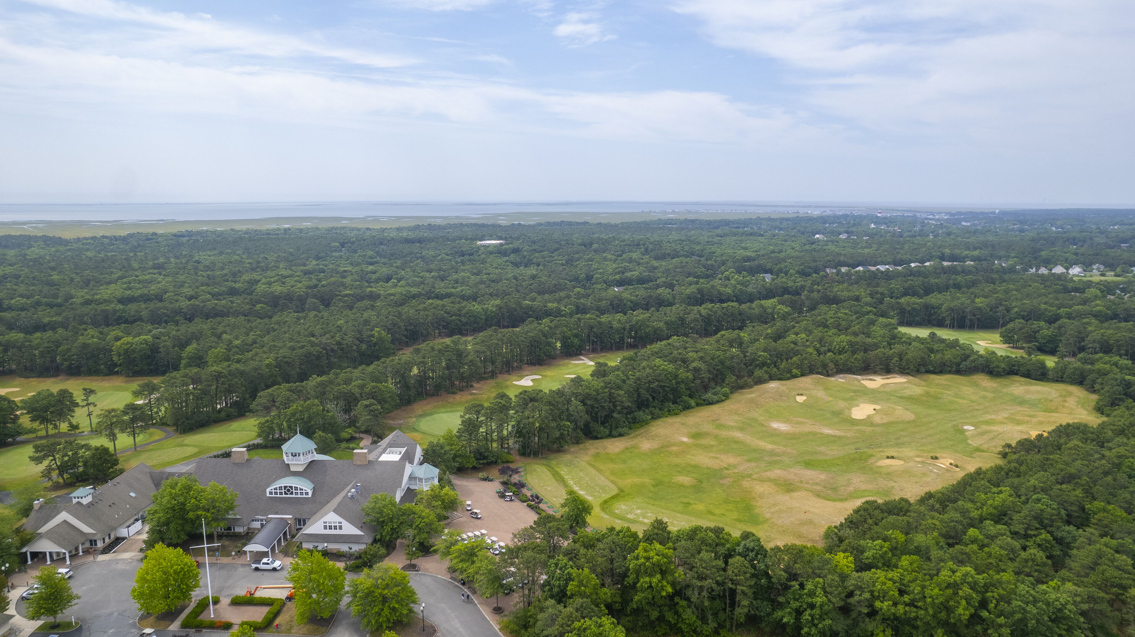 A large estate with multiple buildings, a golf course, and surrounding forested areas.