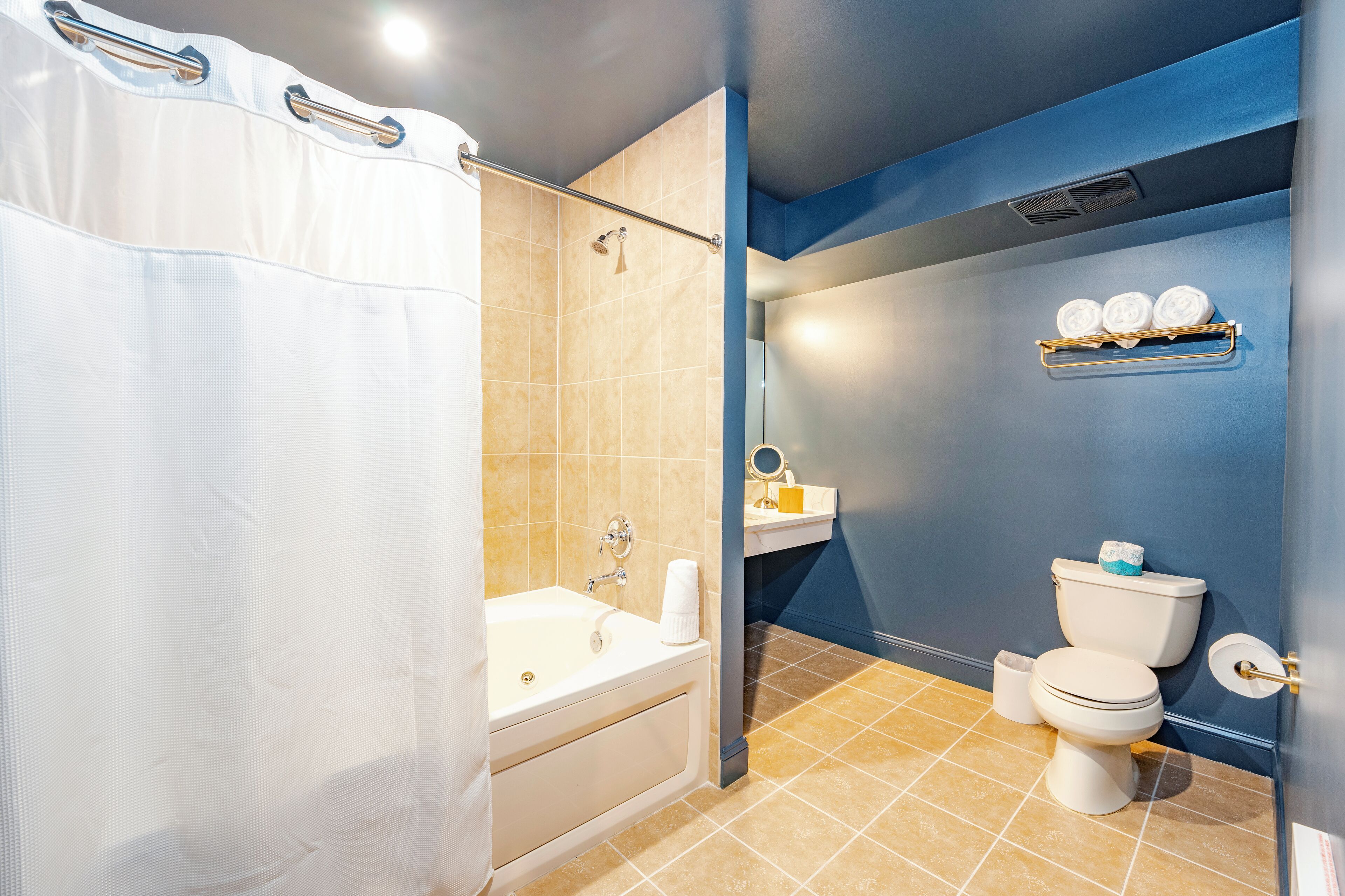 A bathroom with a bathtub, toilet, and a shower curtain.