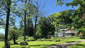 Uma casa rodeada por vegetação exuberante e um céu azul límpido.