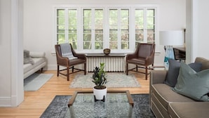 Ein Wohnzimmer mit einer Couch, zwei Sesseln, einem Couchtisch und einer Zimmerpflanze.