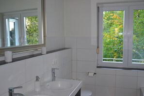 A bathroom with a sink, mirror, and window. - Top apartment / apartment in Kiel-Mitte (UKSH / CAU / stadium) (Kiel)