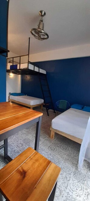 A bunk bed room with a wooden table, a chair, and a ceiling fan. - Estancia del Agua (Xul-Ha)