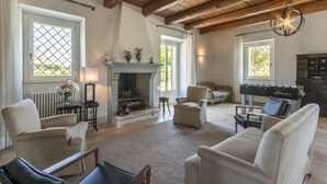 Un salón amplio con chimenea, asientos cómodos y una mesa de fútbol.