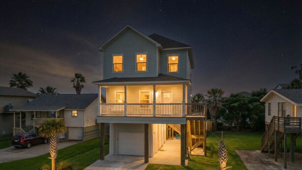 A two-story house with a balcony, a garage, and a driveway.