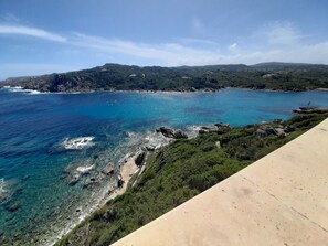 Un paysage côtier caractérisé par une eau d’un bleu limpide, des rivages rocheux et une végétation luxuriante.