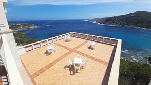 A terrace with a view of the sea, featuring outdoor seating and a railing. - Overlooking the sea Santa Teresa Gallura (Santa Teresa di Gallura)