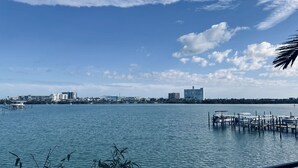 Une vue sur le front de mer, avec un quai, une eau calme et des bâtiments en arrière-plan.