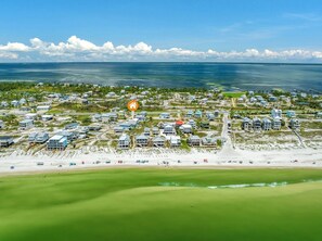 An aerial view of a coastal residential area with houses, a beach, and a clear sky. - Steps to Beach~2 KINGS~Renovated~Dog Friendly~On Cape (Port St. Joe)