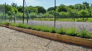 Un jardin clos, avec des allées de gravier et des jardinières en bois.