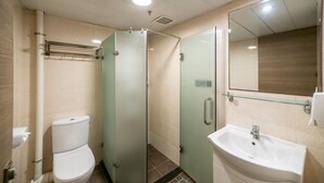 A modern bathroom with a glass shower enclosure, a white sink, and a toilet. - metacity living (Kowloon)