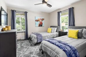 A bedroom with two beds, a ceiling fan, and a large window with curtains. - Winter Special: Close to Everything, remodeled 3 bdrm house, large deck & yard (Marietta)