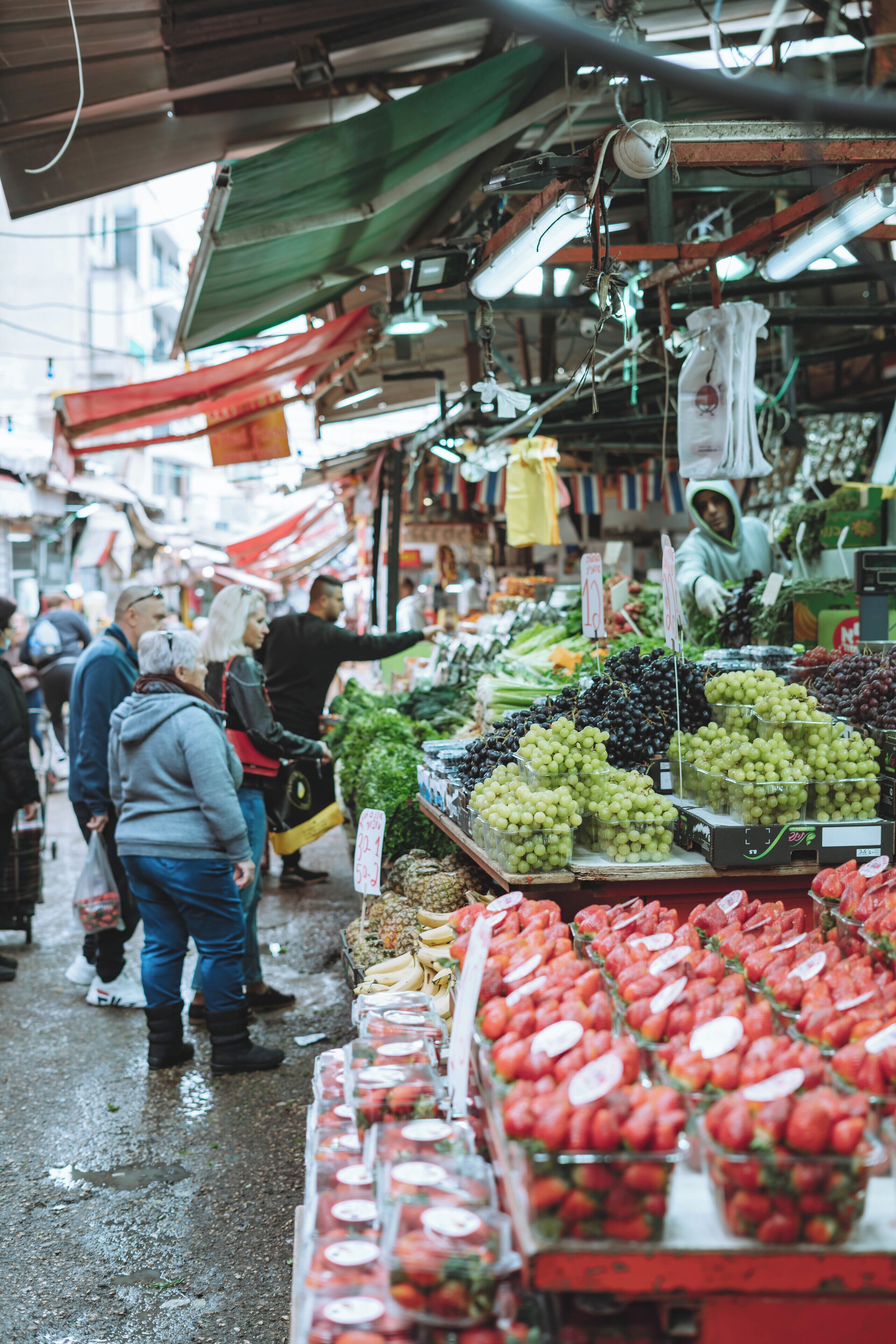 Un mercado interior animado con una gran variedad de frutas y verduras frescas a la vista.
