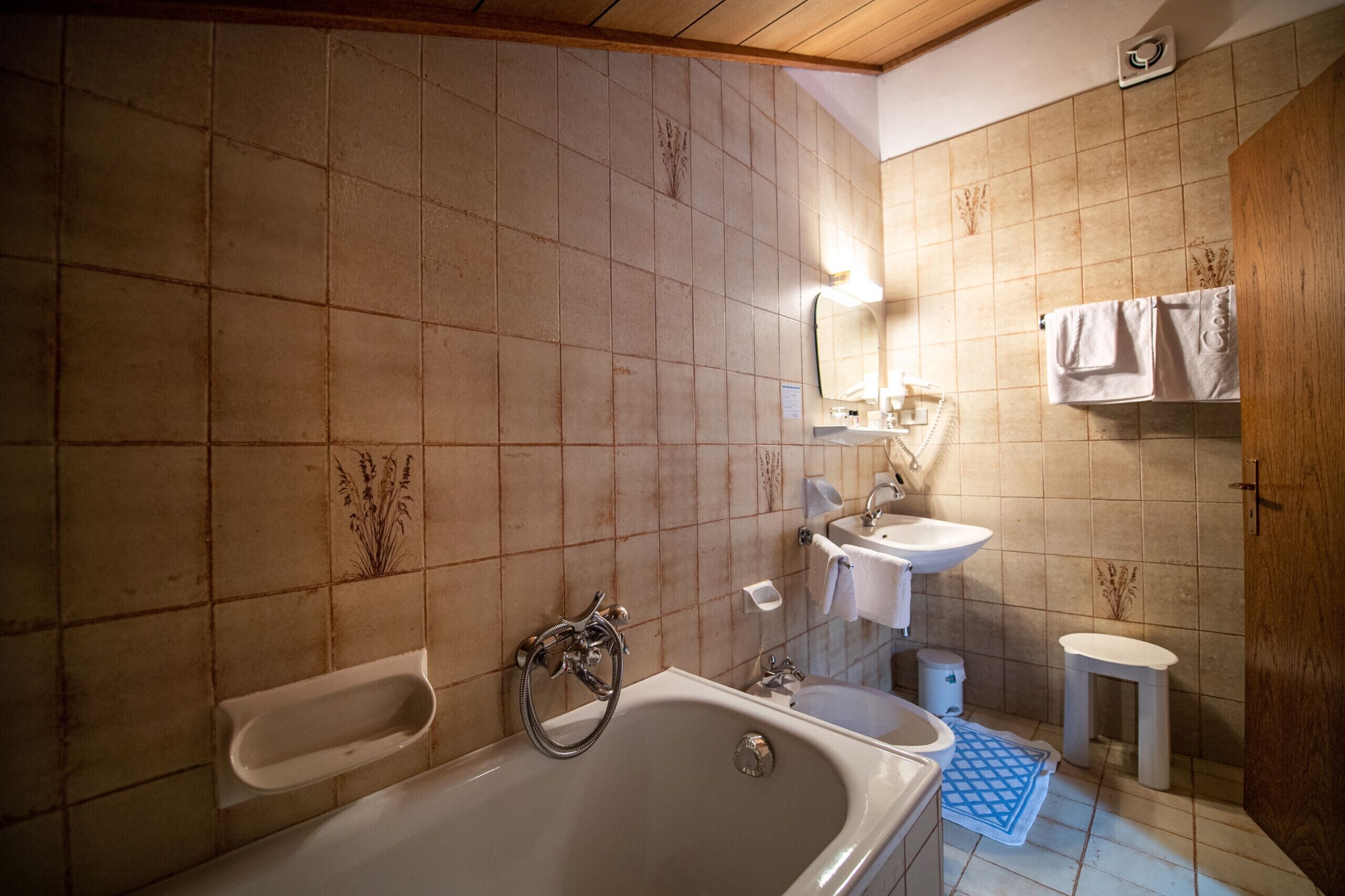 A bathroom with a bathtub, sink, and mirror.