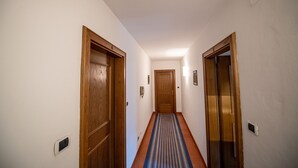 A hallway with wooden doors and a blue striped carpet. - 302A Apartments Garni Zilli (Laion)