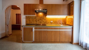 A kitchen with wooden cabinets, a built-in stove, and a countertop sink.