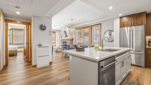 Una cocina moderna con una isla central, electrodomésticos de acero inoxidable y muebles de madera.