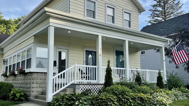 A two-story house with a front porch, a stone foundation, and a small front yard with greenery. - Central House
Home Away From Home! (Bluffton)