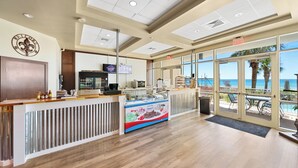 A beachside café with a view of the ocean, a Hershey's ice cream display, and a sign reading "Welcome".