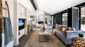 A modern living room with a fireplace, a sofa, a coffee table, and a TV.