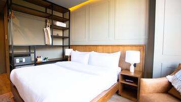 A neatly made bed with white linens, a wooden headboard, and a bedside table with a lamp.