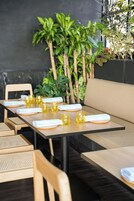 Un restaurante con una larga mesa dispuesta para comer, rodeada de sillas y un banco.