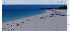 A beach with clear blue water and white sand.